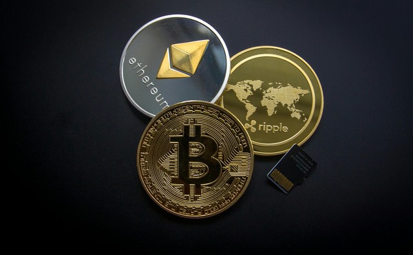 Bitcoin, Ethereum, and Ripple cryptocurrency coins on a dark background