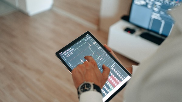 Tablet screen displaying a cryptocurrency candlestick trading chart