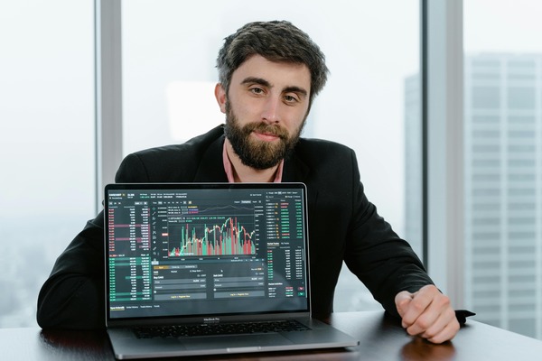 Person presenting a cryptocurrency exchange trading interface on a laptop