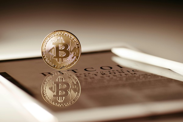 Bitcoin coin resting on a peer-to-peer electronic cash system document